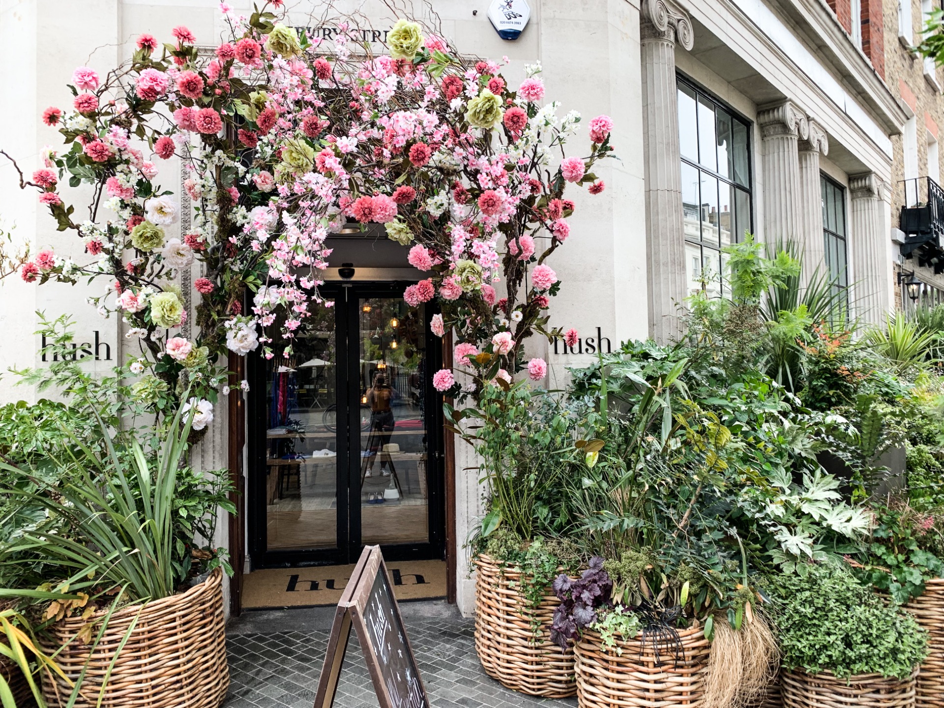 Blomsterprydd entré med rosa och vita blommor, symboliserar hur vi växer i trygga och närvarande möten med andra.